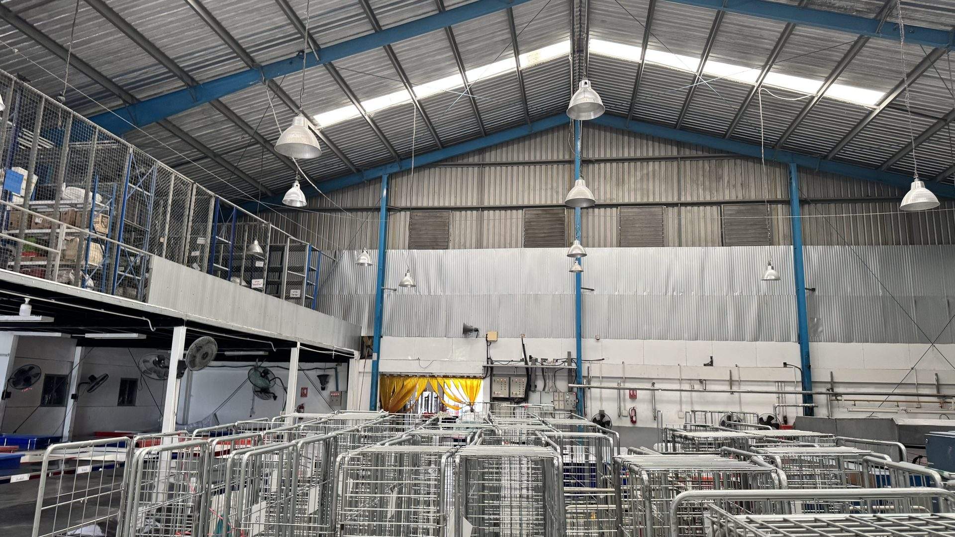 Wide view of PEO's industrial laundry facility with linen handling carts and mezzanine storage